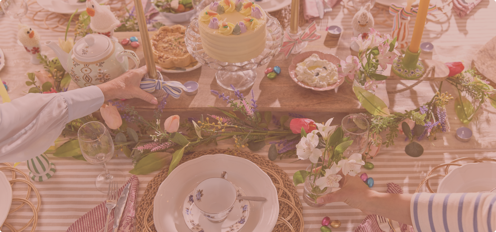 Decorated table with Easter-themed items including a cake, eggs, and flowers.