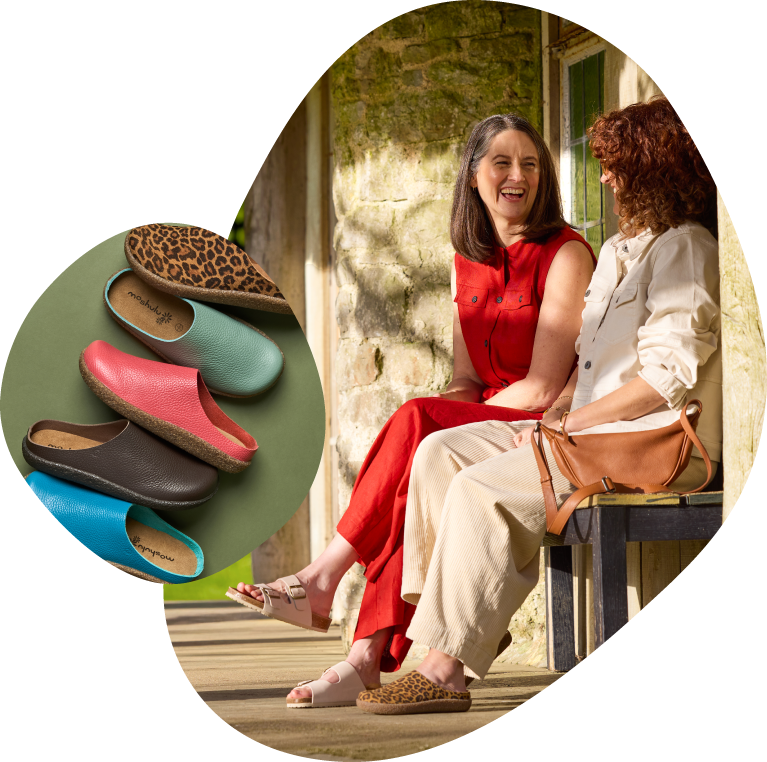 Two women sitting outdoors with a close-up of colorful sandals on a green background.